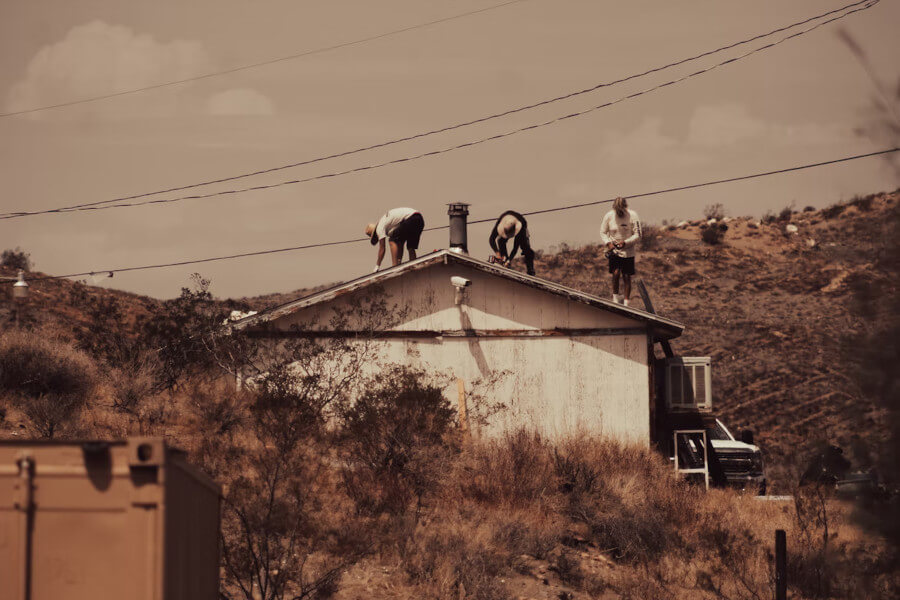 3 people working on a roof