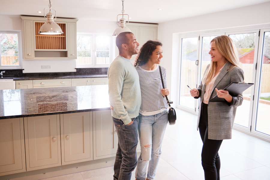 real estate broker talking to a couple in a kitchen