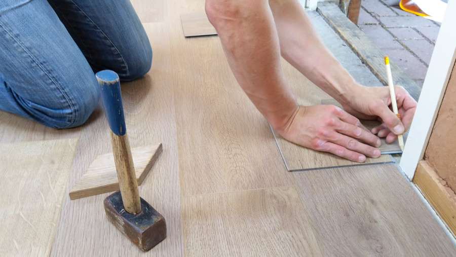 Person holding Pencil, installing flooring