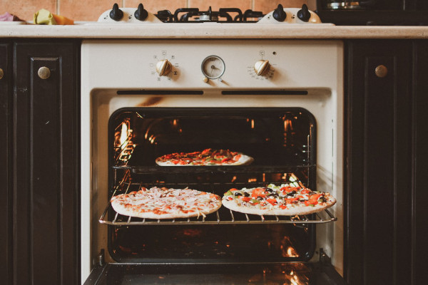Ann open oven with 3 pizzas inside