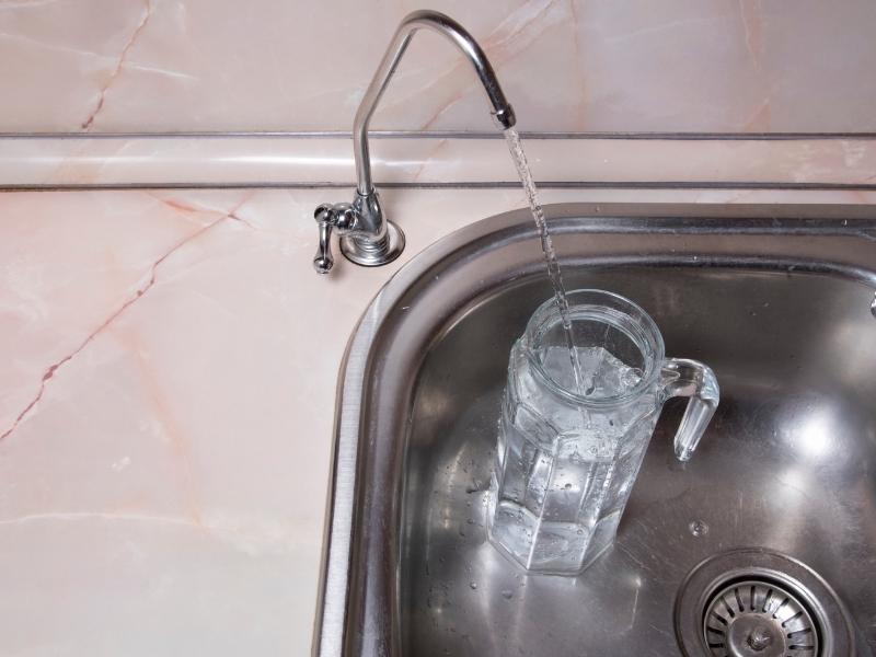 glass in a sink being filled with water