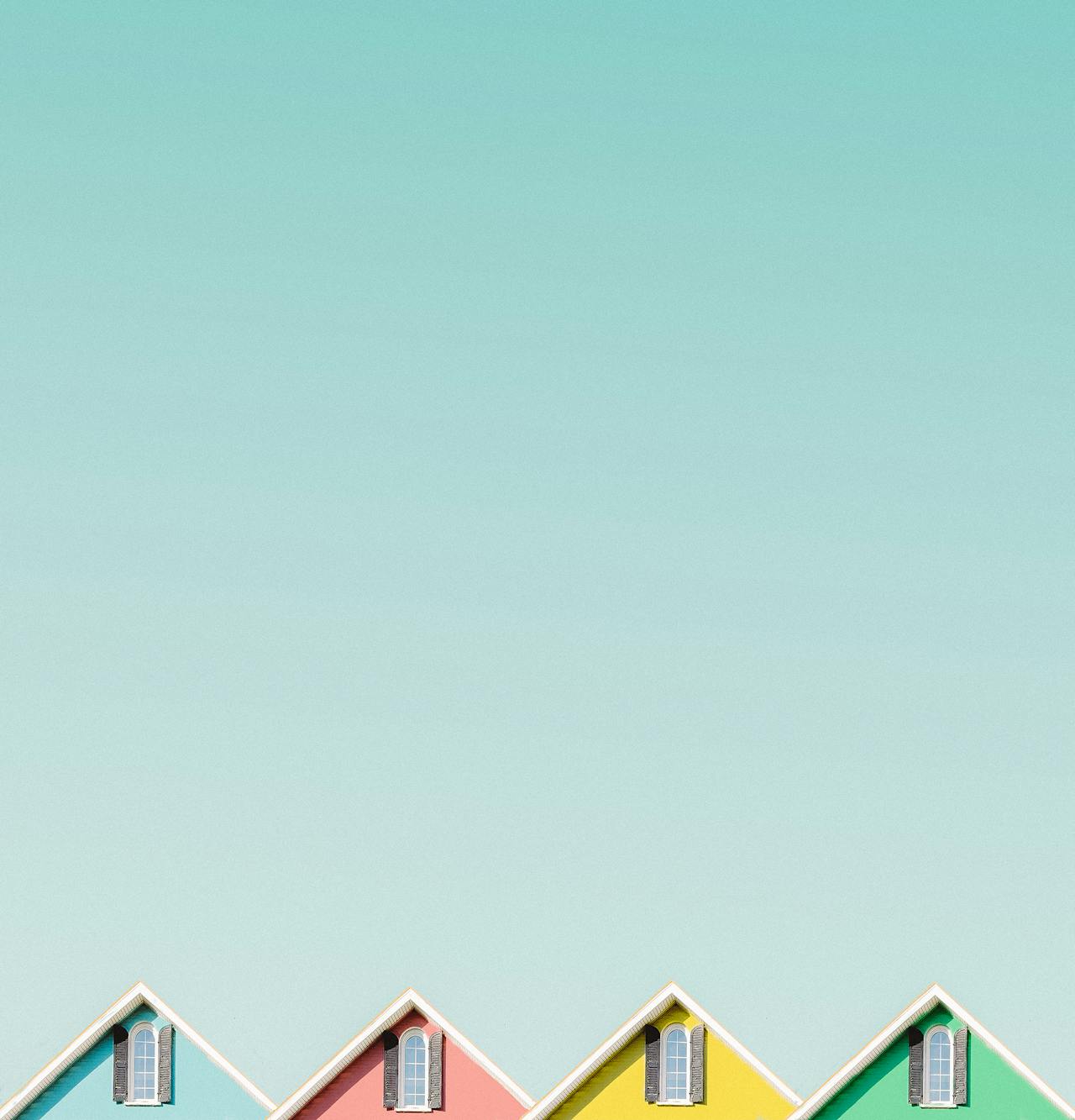 The top of 4 colorful houses. Image by Pexels