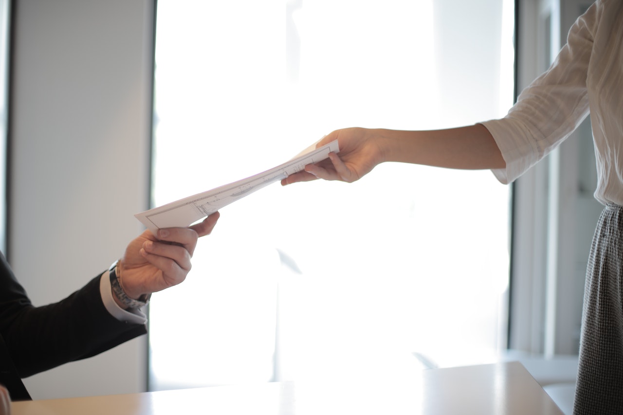 person handing over papers