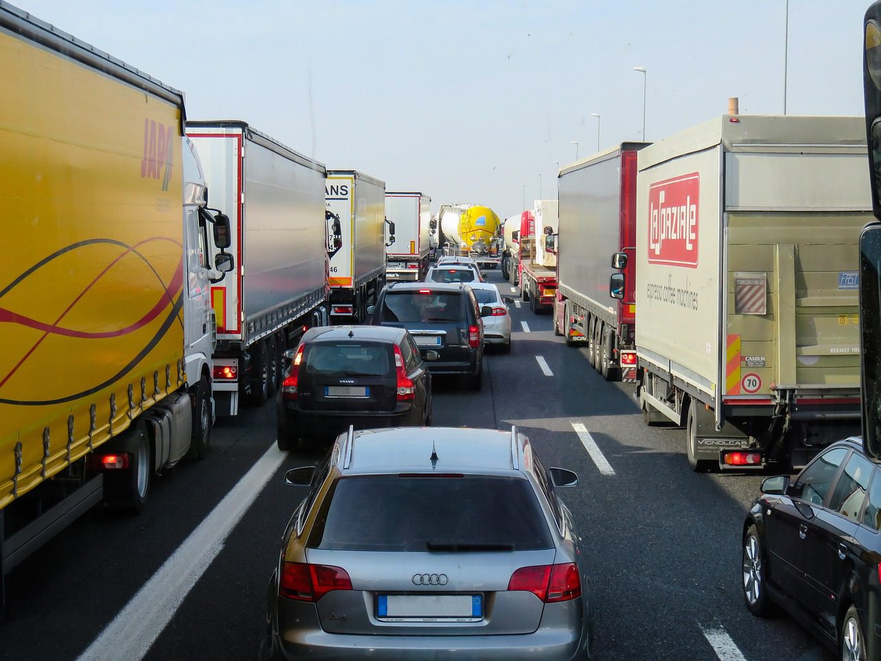 Traffic jam with commercial trucks on a highway. Image by Pixabay