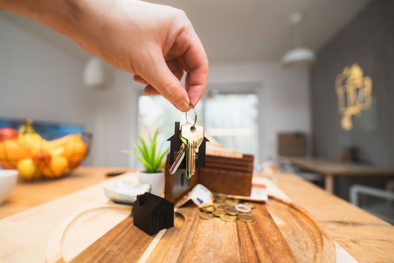 Person holding up keys in the kitchen. Image by Pexels