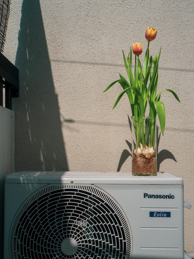 air conditioning unit with tulips on top of it
