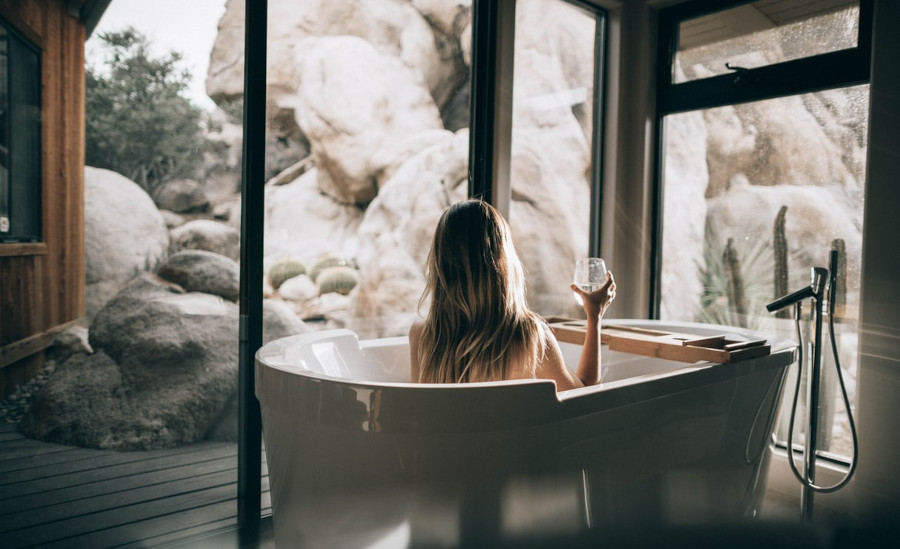 Modern, bathroom, person in a bathtub with a glass in their hand