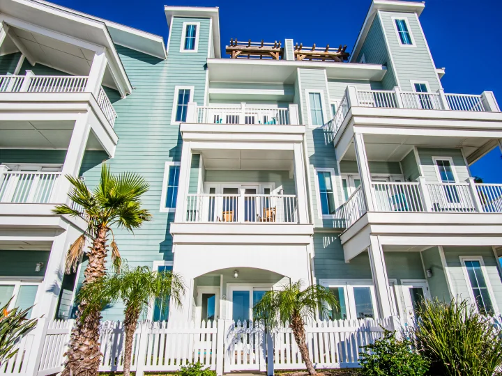 Silver Sands Vacation Rentals, green apartment building with white balconies