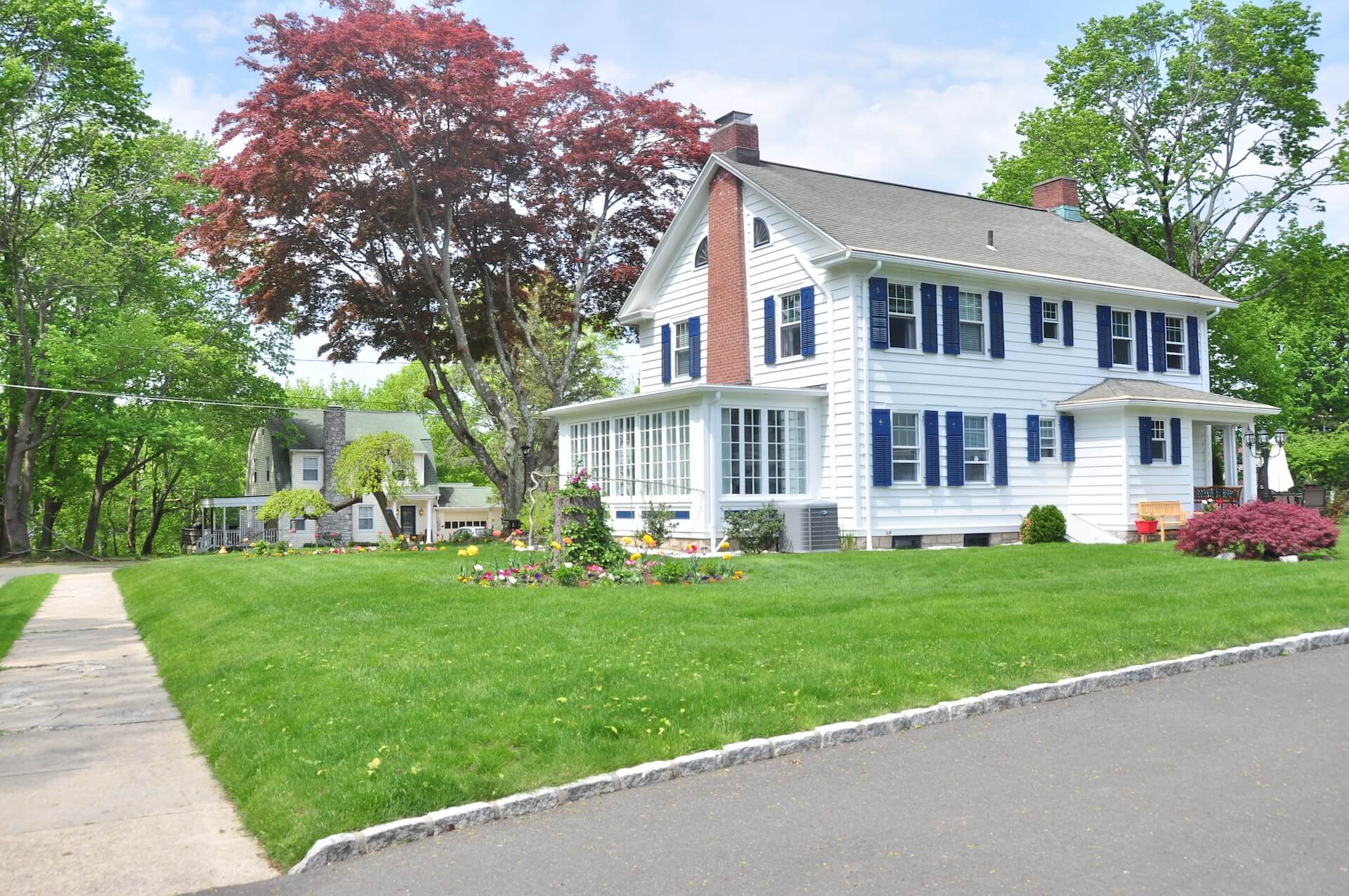 white single-family house, blue shutters, green lawn
