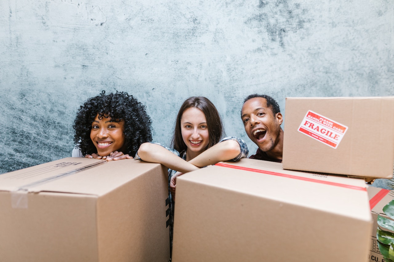 3 people behind moving boxes