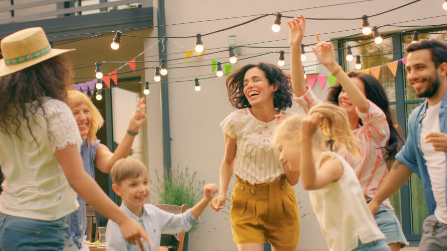 People dancing in a backyard. Stringlights hanging.