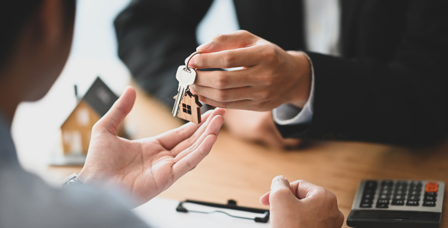 person handing over keys to another person