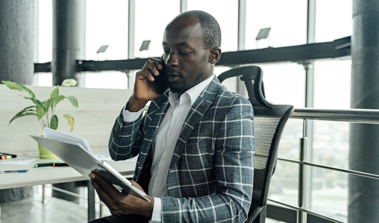 Person on the phone, holding papers