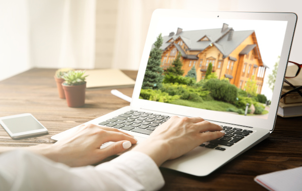 person looking at a house on a laptop