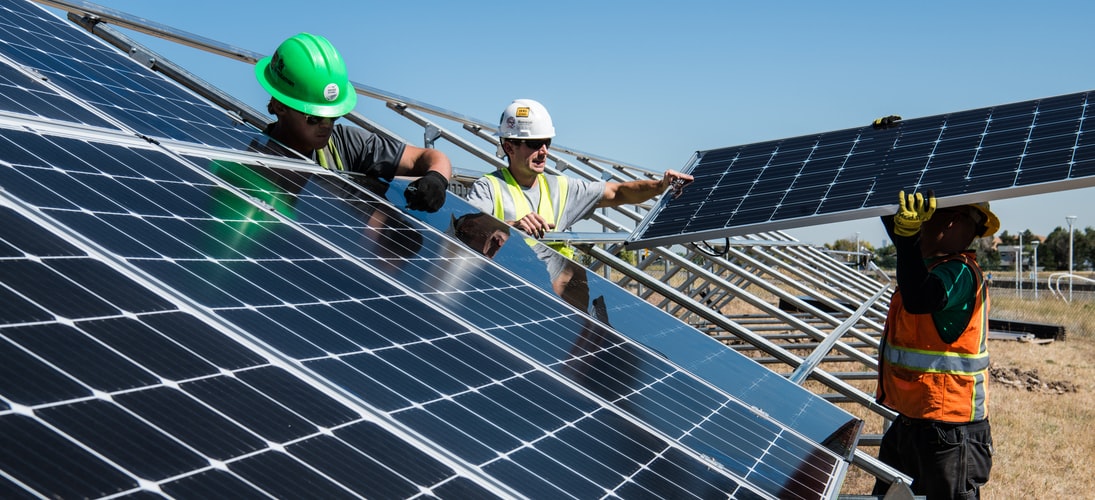 3 people installing solar panels.