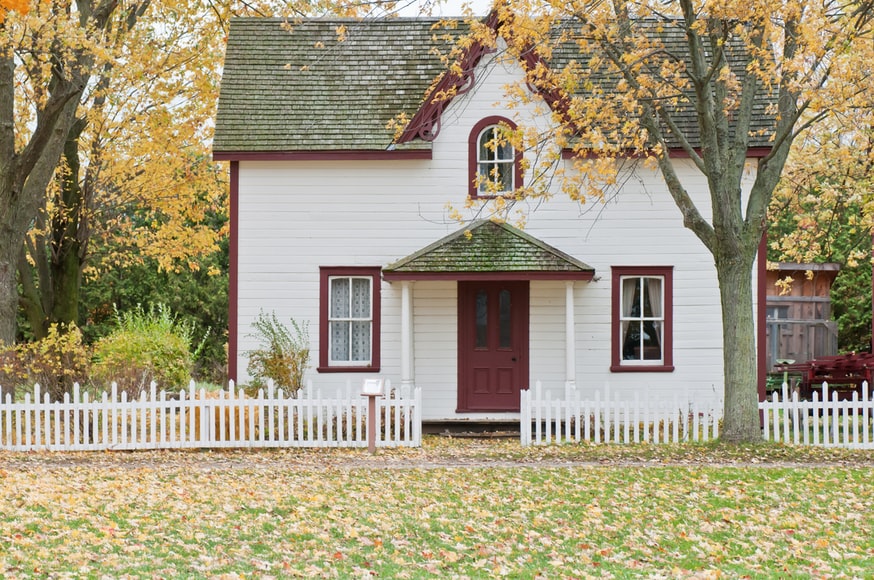 house with lots of fall leaves on the ground