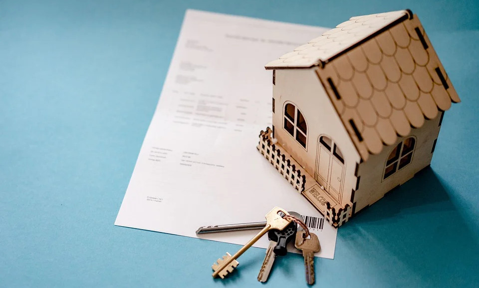 house keys and a small house on a piece of paper