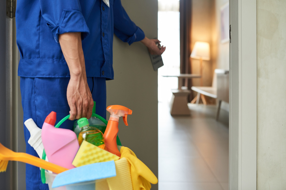 Person holding a bucket with cleaning supplies