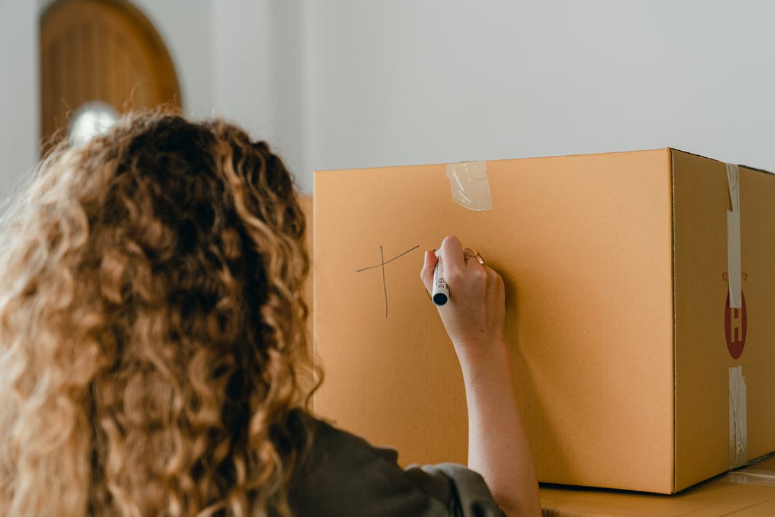 person writing on a box