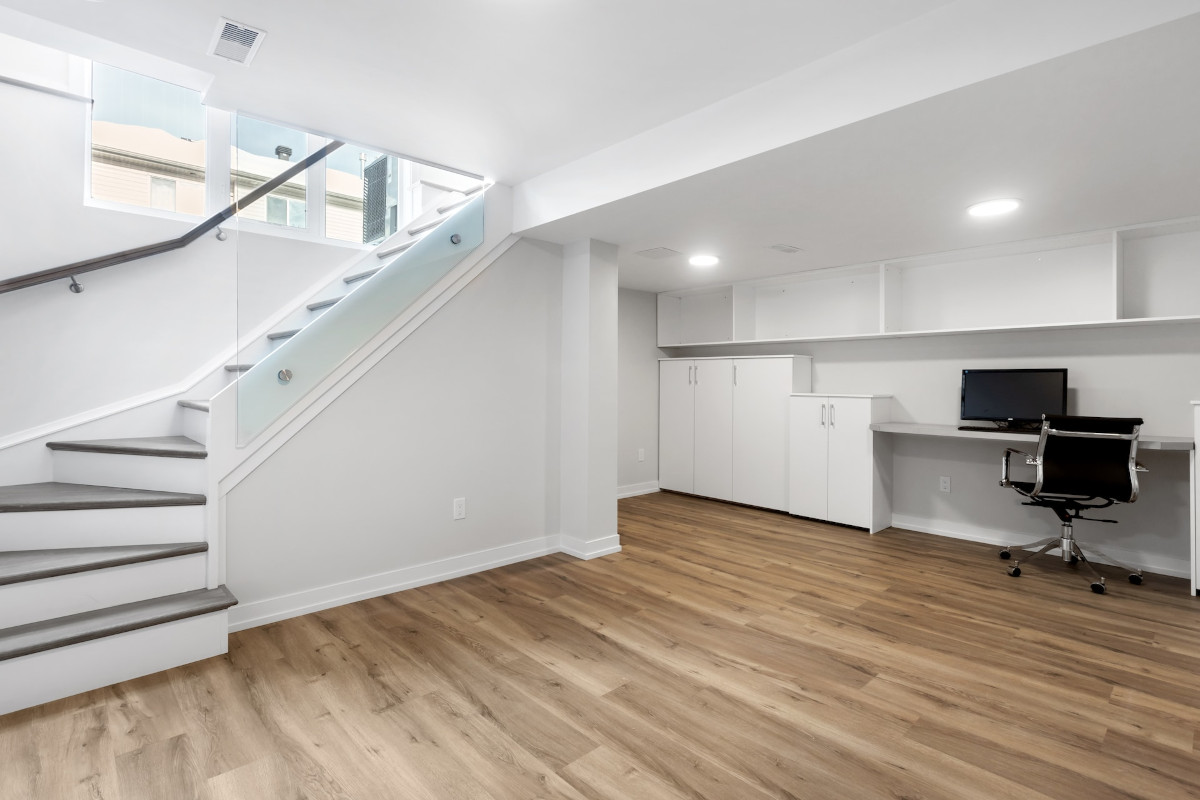 empty room with built-in desk and a chair on a lower level. Image from Unsplash