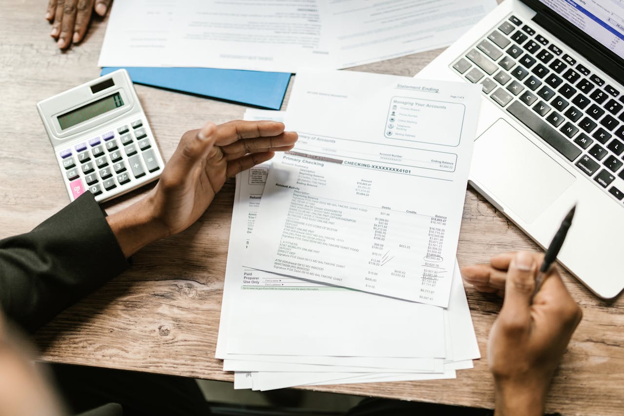 Paperwork, laptop and a calculator on a table