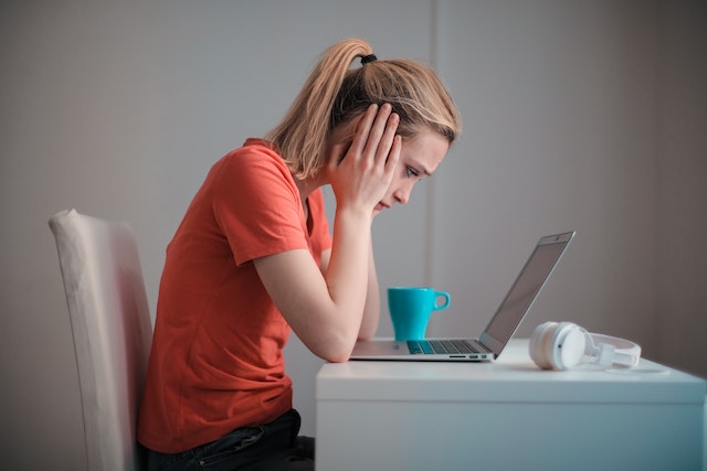 Person covering her ears while she's trying to work