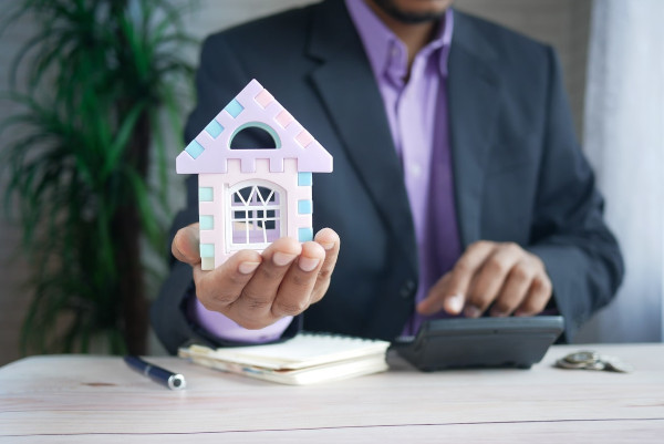 person with purple shirt holding a purple house.