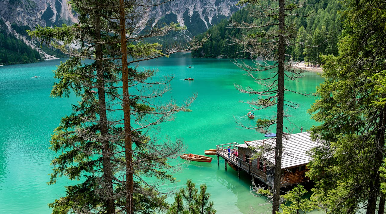 Brown wooden dock, wooden kayaks in the water. Image by Pexels