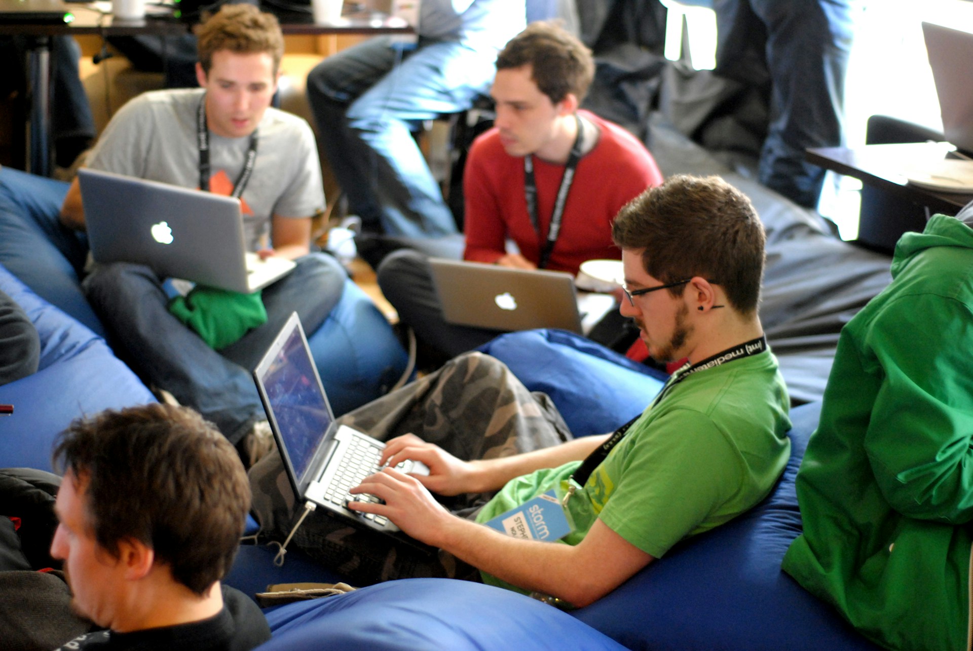 People working on laptops, sitting on beanbags. Image by Unsplash