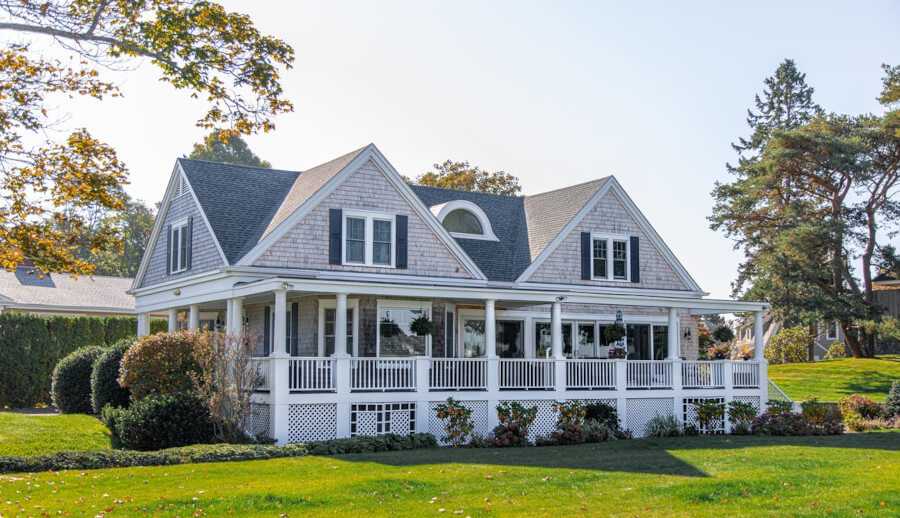 Grey house with a large wrap around porch