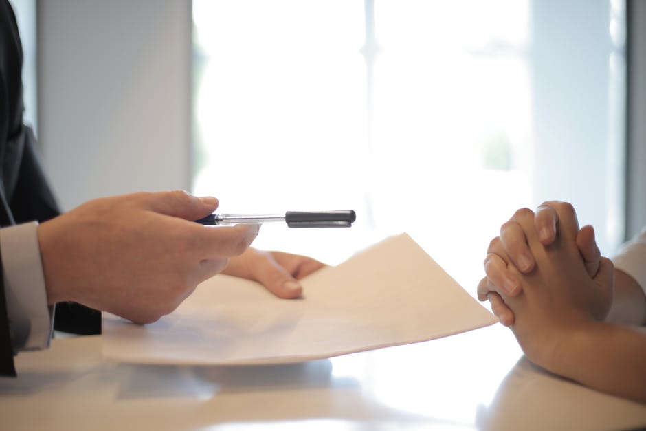 Person holding a pen and paper in his hands