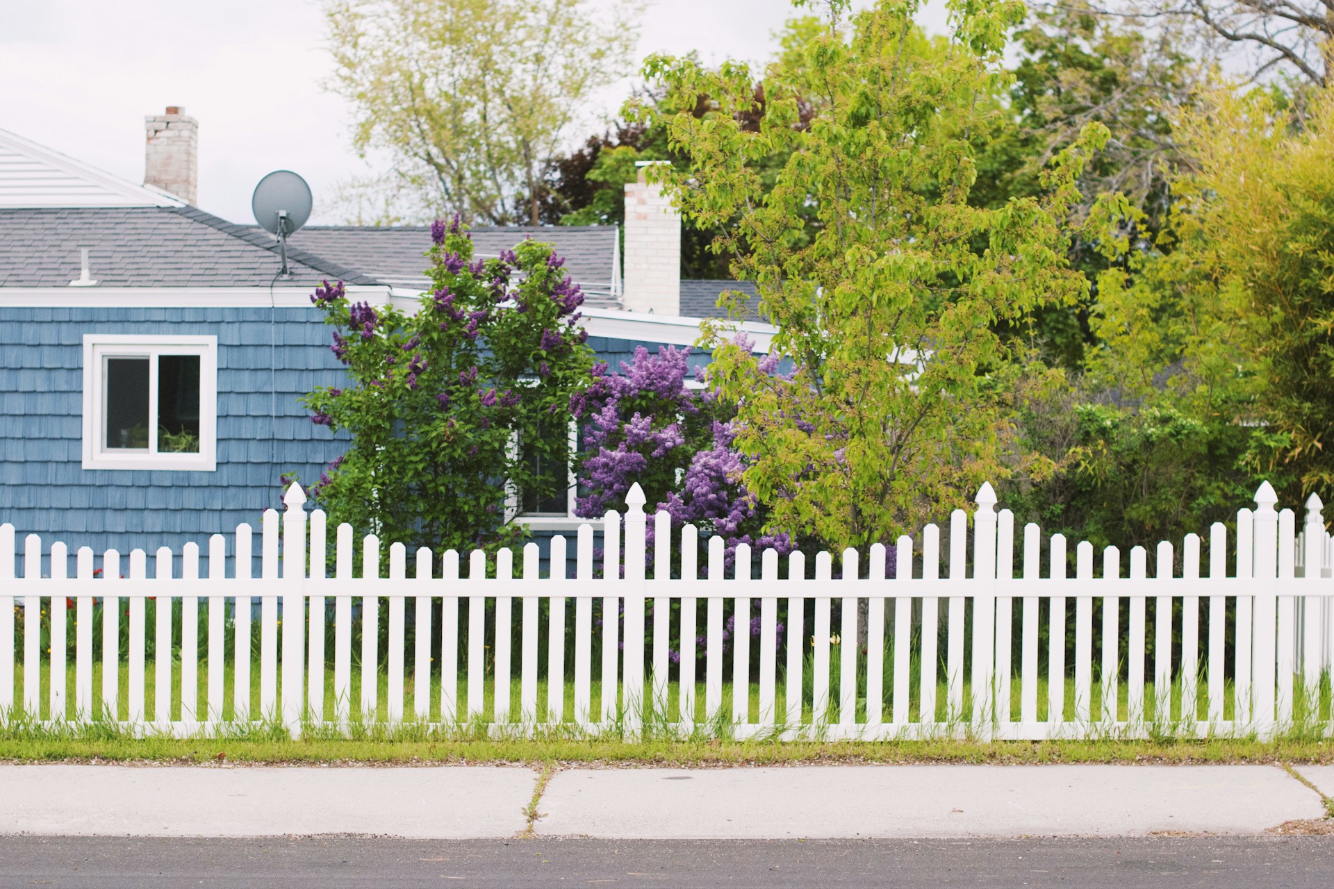 Blue house with a white fence