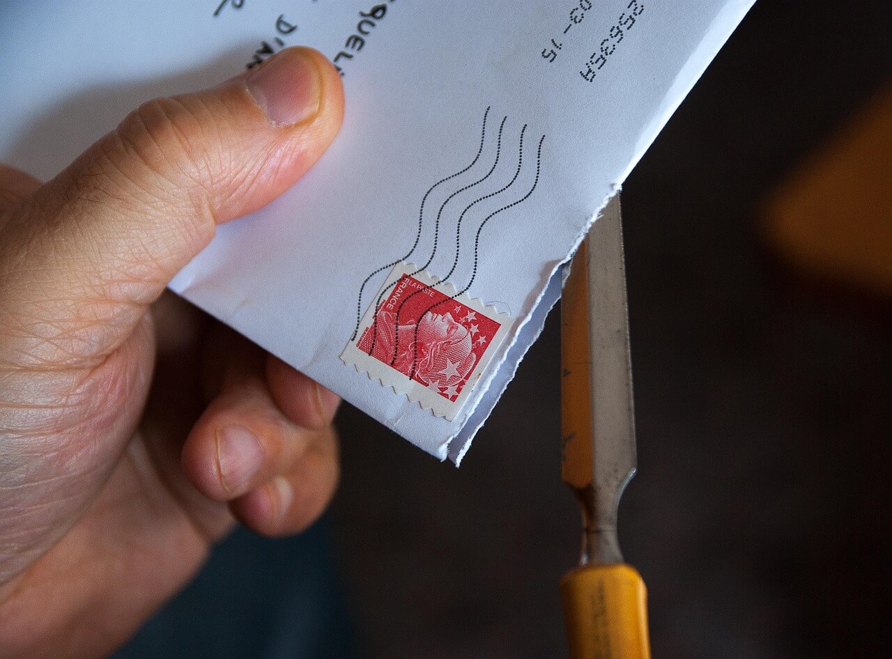Person holding an envelope. Image by Pixabay