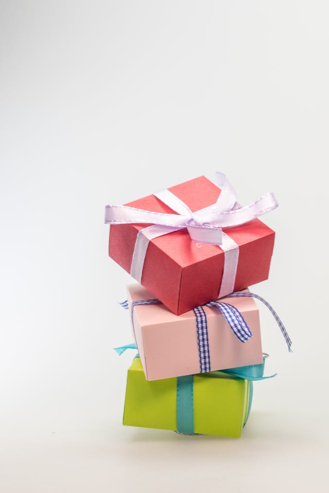 3 different colored gift boxes stacked on top of each other. Image by Pexels