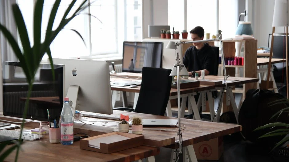 Office deskts with computers, 1 person working