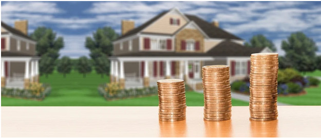 coins stacked in three piles, houses in the background