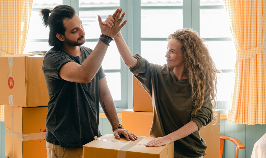 2 people giving high fives, packing boxes