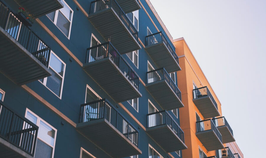 Apartment Buildings with balconies. One building is blue, the other one is orange