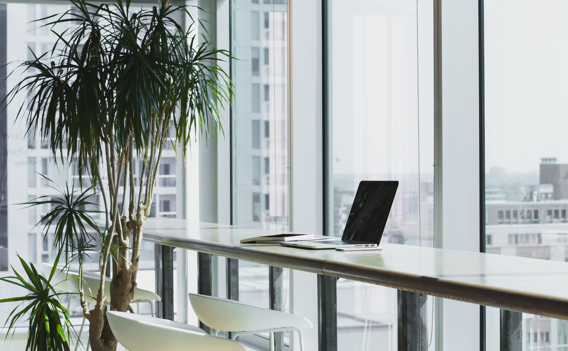 Large desk, chairs, laptop, large windows