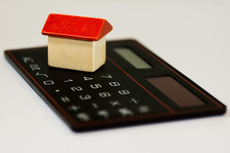 wooden house on top of a calculator