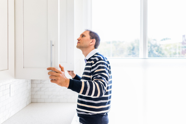 Person looking into a kitchen cabinet