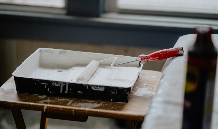 Painting tray, paint roller on a wooden table