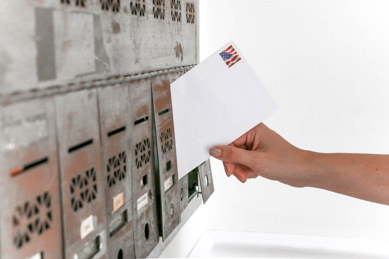 white envelope in front of silver mailboxes