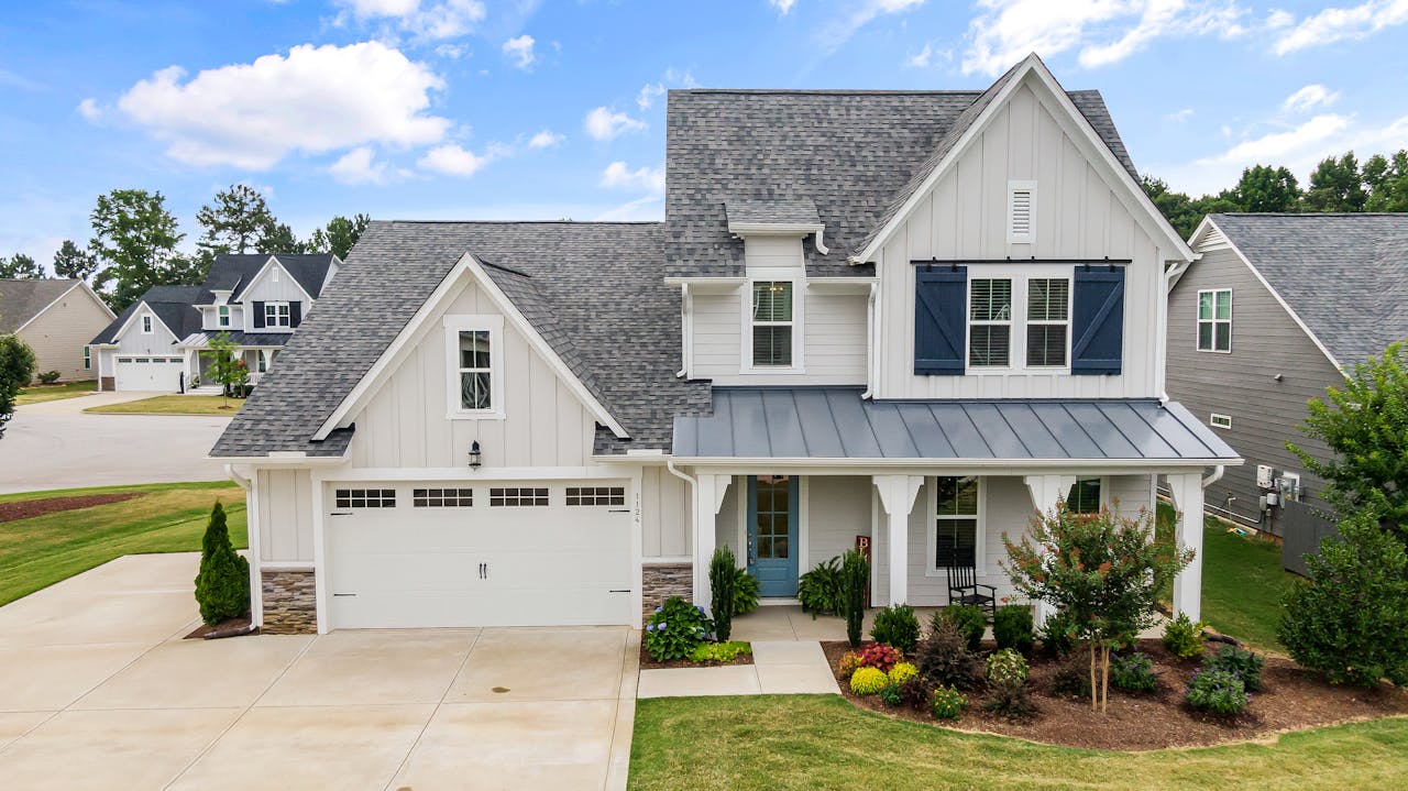 White house in the suburbs. Nice landscaping. Image by Pexels