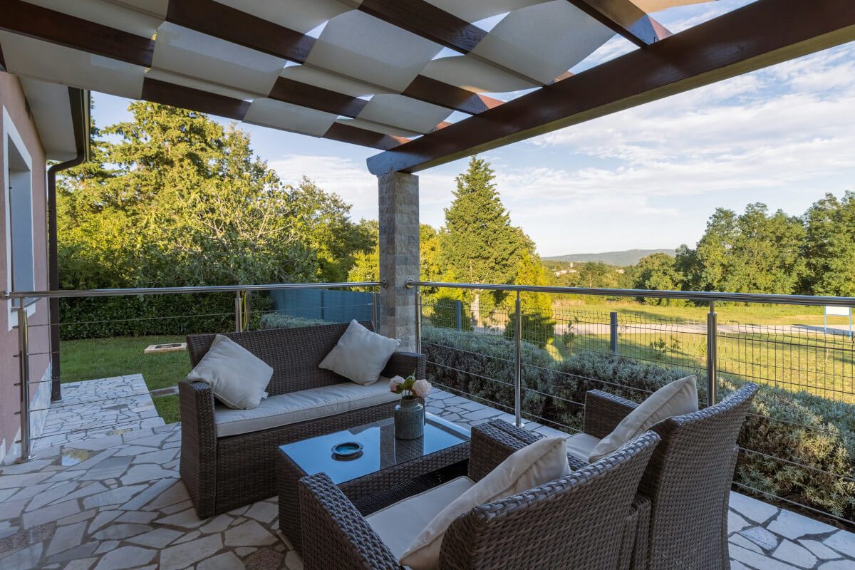 patio with brown wicker chair and table. Image by Unsplash