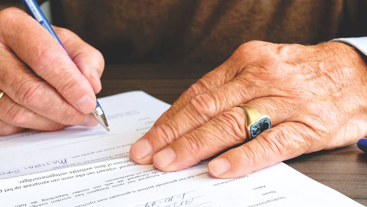 Person signing papers. Image  by Pexels