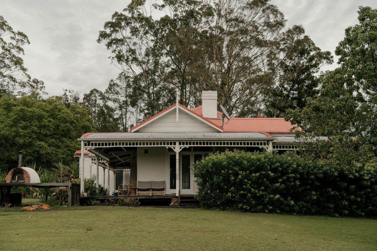 White house with a red roof surrounded by trees. Image by Unsplash