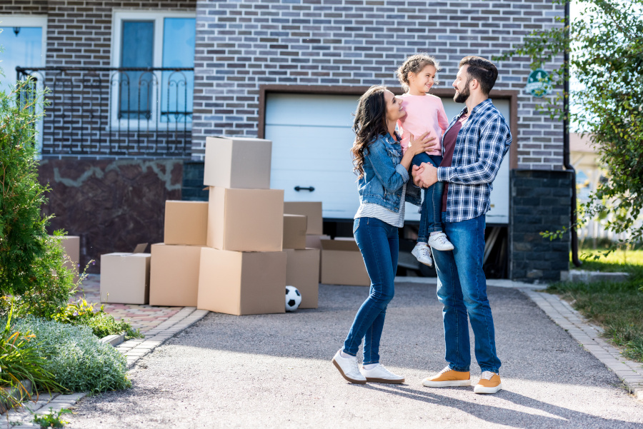 family outside a house, lots of moving boxes