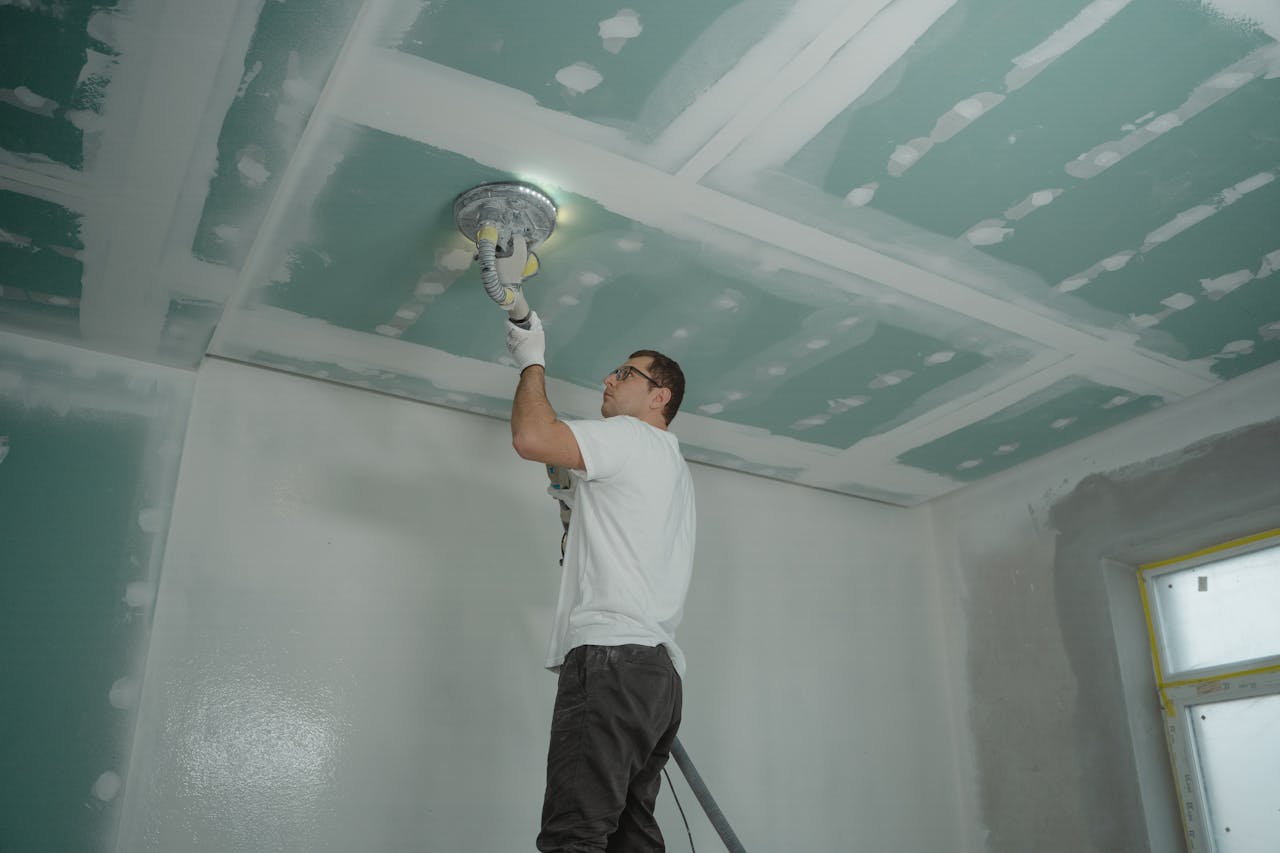 people preparing a wall to be painted