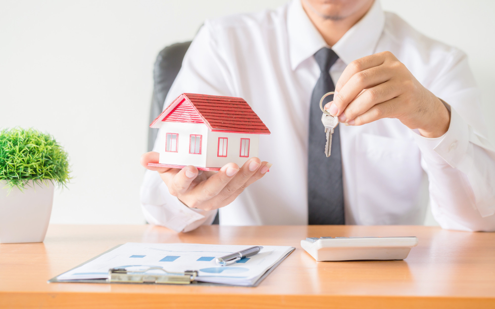 Person holding a house and keys in their hands. Image by Freepik